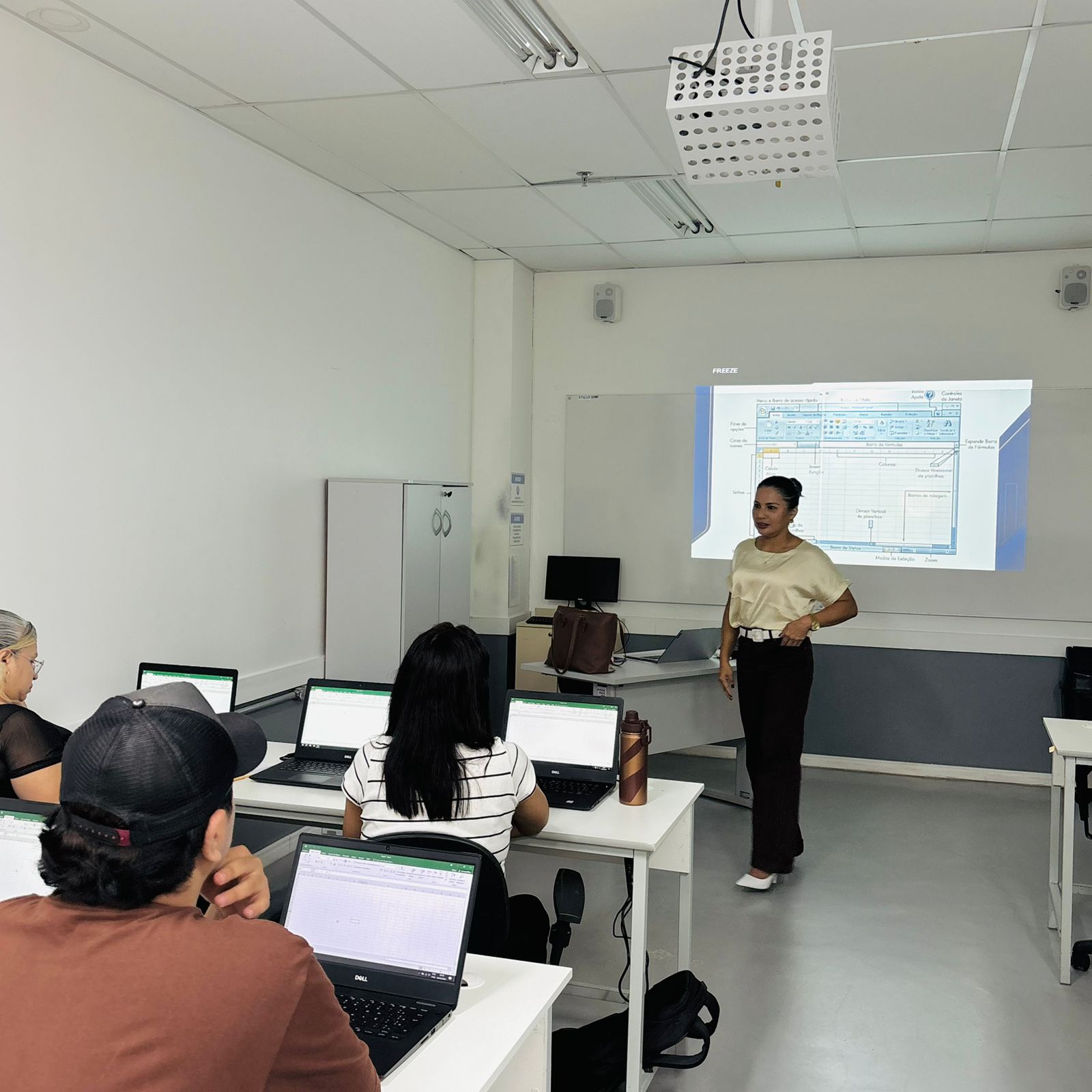 Instrutora em sala de aula durante treinamento de Excel